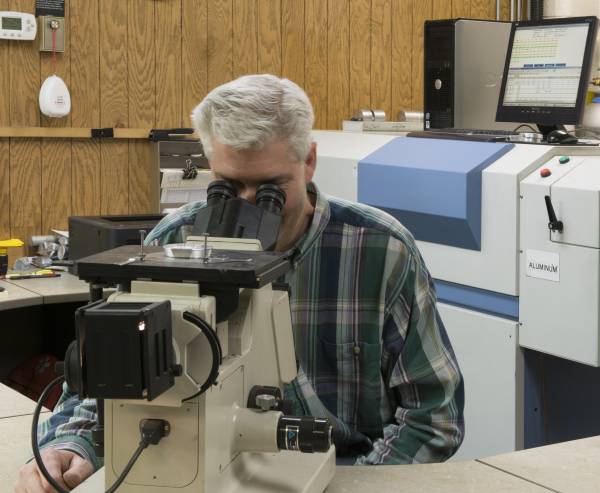 a person looking through an eyepiece of a microscope